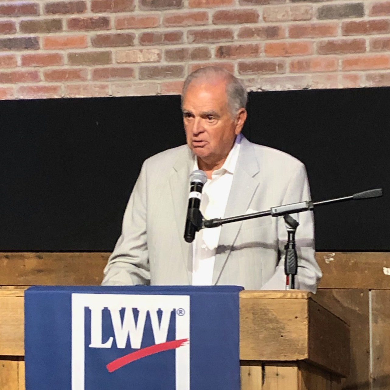 Ray Lahood speaking in front of a podium with a LWVGP banner.
